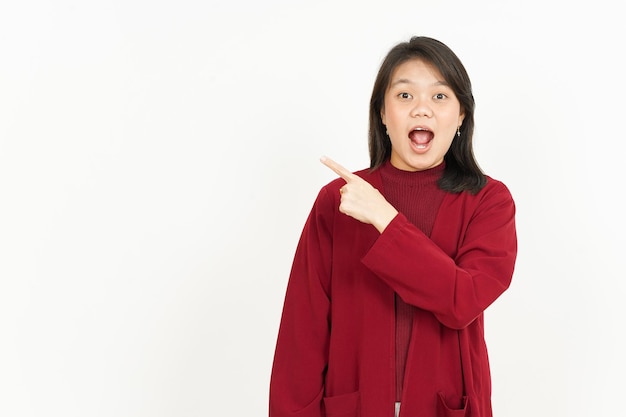 Puntando il lato del prodotto della bella donna asiatica che indossa una camicia rossa isolata su sfondo bianco