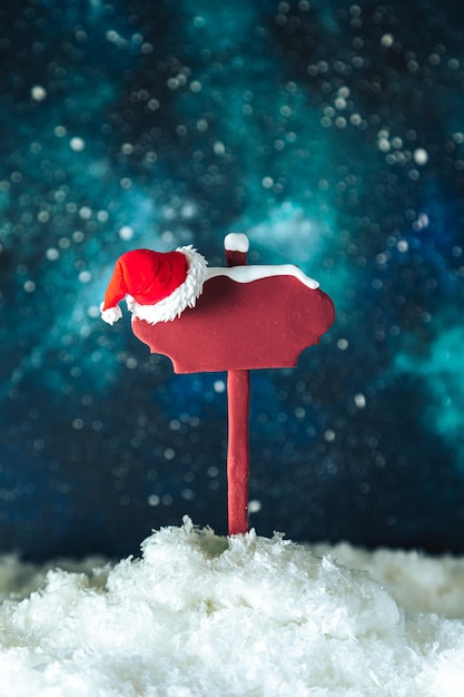Puntatore in legno e cappello di Babbo Natale sullo sfondo del cielo stellato notturno