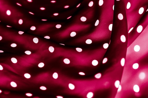 Puntini bianchi di struttura del fondo del tessuto del puntino di polka classico sul modello di disegno del tessuto di lusso rosso
