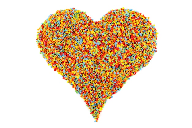 Puntini colorati di cospargere di zucchero disposti a forma di cuore isolati su bianco