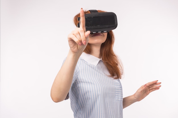 Punto di donna premendo il touch screen dalla realtà virtuale su sfondo bianco. Dispositivo per occhiali con visore VR