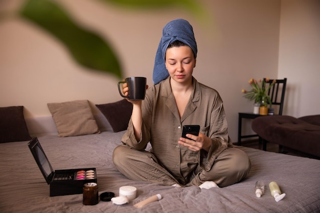 Punto di vista completo della donna fresca che si siede al telefono con una tazza di caffè