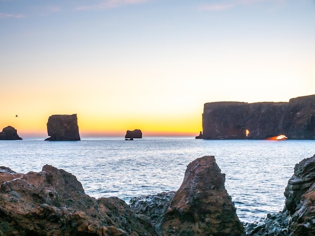 Punto di vista dell'arco di Dyrholaey vicino alla città di Vik nel sud dell'Islanda durante il cielo della sera crepuscolare lungo la costa