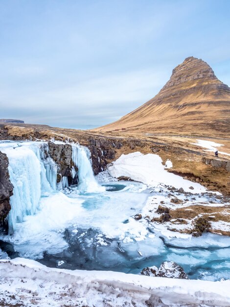 Punto di vista della montagna di Kirkjufell e della cascata di Kirkjufellfoss in Islanda l'acqua gela per essere ghiaccio