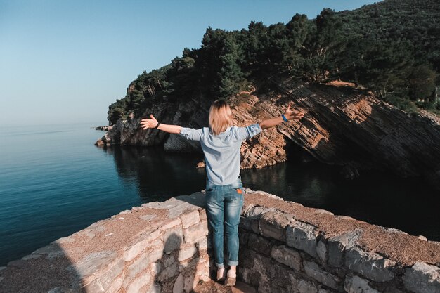 Punto di vista posteriore della donna che pensa da solo e che guarda il mare con l'orizzonte nei precedenti, Montenegro