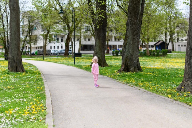 Punto di vista posteriore della ragazza che cammina Outoodrs nel parco