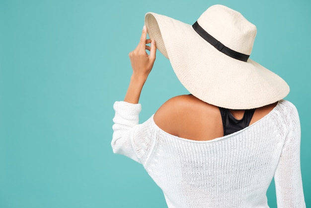 Punto di vista posteriore di bella giovane donna in cappello di estate