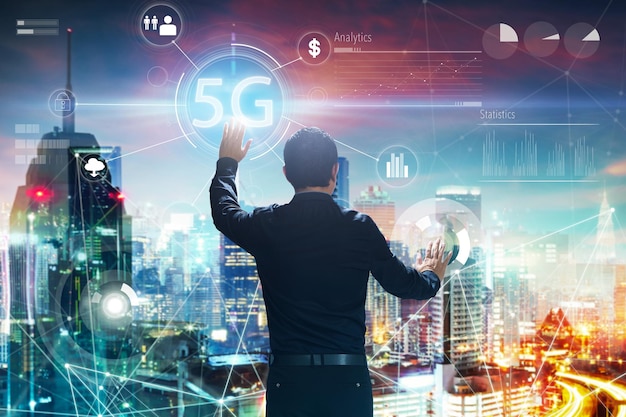 Punto di vista posteriore di un uomo d'affari che tocca la parola 5G sullo schermo virtuale digitale Concetto di affari dei sistemi senza fili della rete 5G