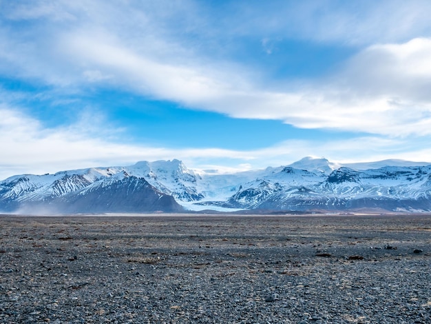 Punto di vista sul picco di Hvannadalshnukur con un'ampia pianura di sabbia vulcanica nera marmorizzata in Islanda