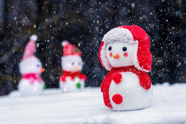 Pupazzi di neve nella neve su uno sfondo scuro durante una nevicata