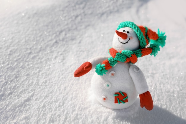 Pupazzo di neve del giocattolo il giorno gelido soleggiato. Vacanze invernali