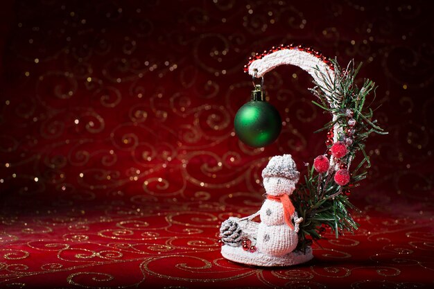 Pupazzo di neve giocattolo su sfondo bokeh. Carta di Capodanno. Giocattolo dell'albero di Natale. Decorazione per la vacanza.