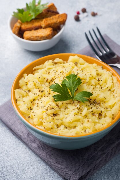 Purè di patate con erbe, crostini e limone in un piatto su tovaglioli.