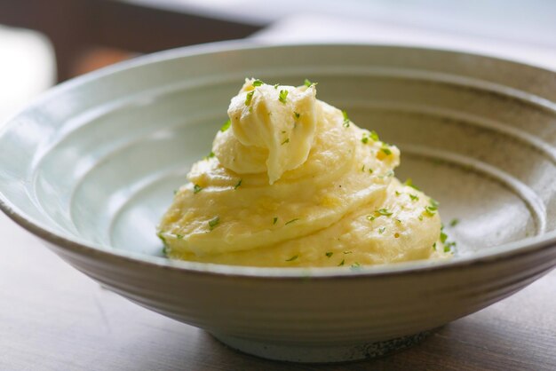 Purè di patate in una ciotola su tavola rustica in legno