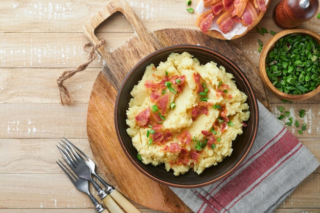 Purè di patate Purè di patate al bacon con cipolla verde pepe e formaggio cheddar in ciotola su vecchi sfondi di legno Delizioso purè di patate cremoso Vista dall'alto