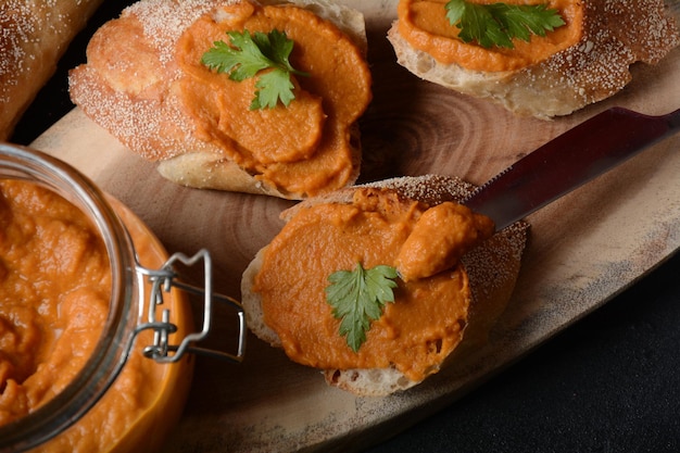 Purea di zucca (caviale di zucca) in un barattolo di vetro e su fette di pane. Caviale di verdure fatto in casa