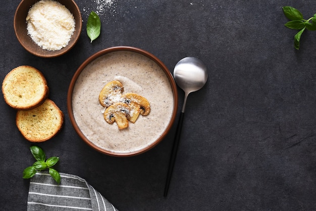 Purea di zuppa con funghi e formaggio su uno sfondo di cemento.