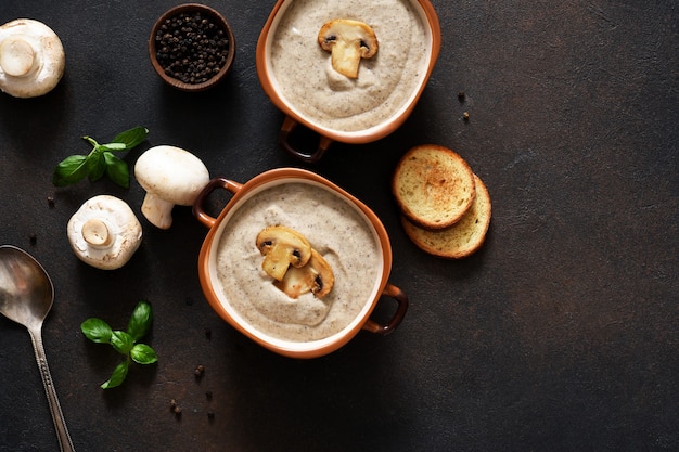 Purea di zuppa con funghi e formaggio su uno sfondo di cemento.