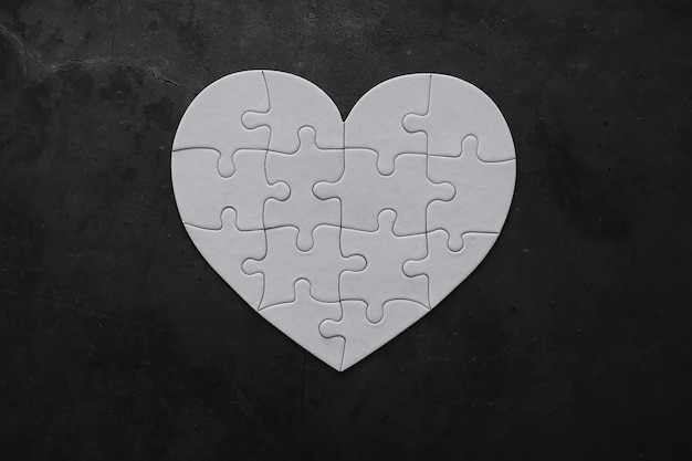 Puzzle a forma di cuore bianco. Affari di cuore. Amore indiviso. Cuore spezzato. La chiave del cuore. Cuore chiuso su una serratura. Concetto di amore.