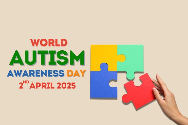 Puzzle del giorno dell'autismo a mano e testo su sfondo beige