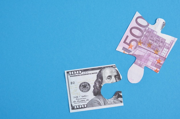 Puzzle di banconote e dollari in euro su sfondo blu