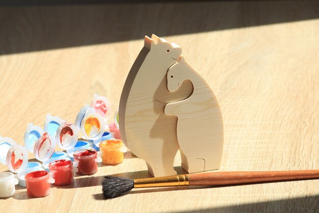 Puzzle giocattolo in legno a forma di animale e vernice colorata su sfondo di struttura in legno