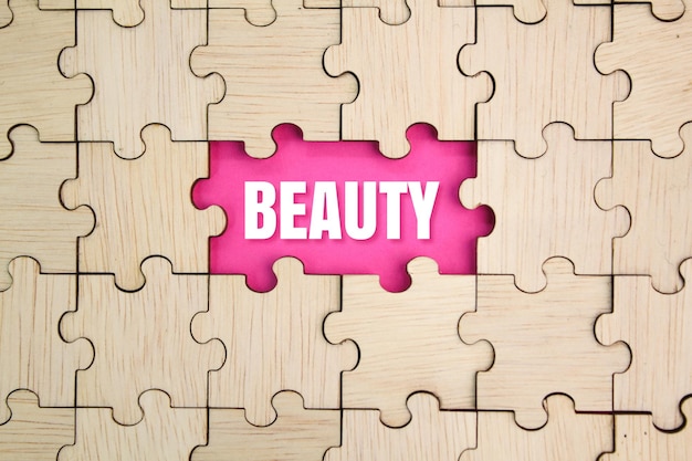 puzzle in legno con la parola bellezza al centro il concetto di bellezza femminile o bellezza naturale