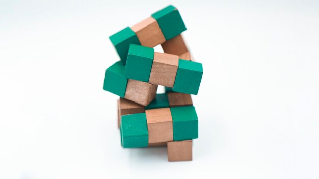 Puzzle irrisolto del cubo del serpente di struttura di legno di colore verde e marrone 3x3 su fondo bianco