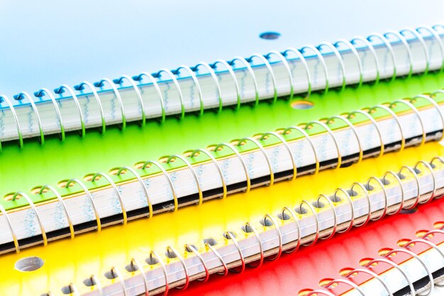 Quaderni a spirale multicolori su sfondo bianco.