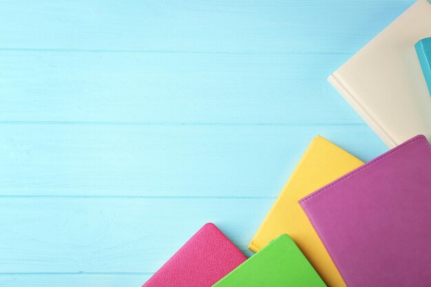 Quaderni colorati su fondo di legno
