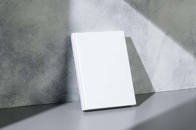 Quaderno bianco con copertina rigida su sfondo grigio