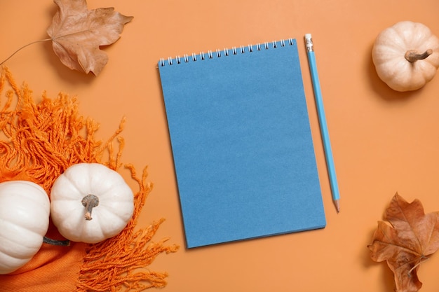 Quaderno bianco per testo e zucche con foglie autunnali Tema autunnale mock up