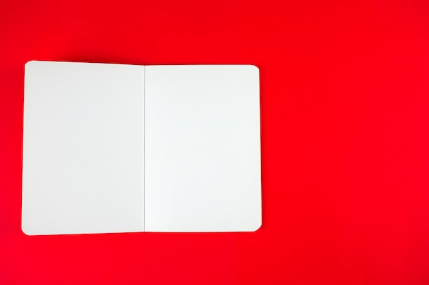 Quaderno di carta vuoto vuoto o mockup di libro su sfondo rosso Blocco note di carta vuoto bianco