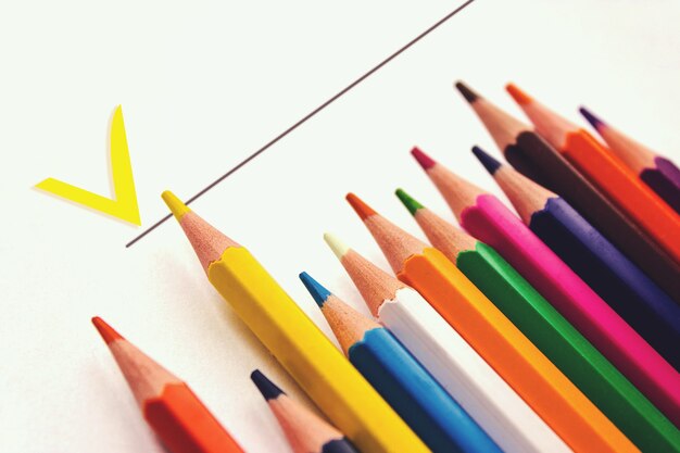 Quaderno di scuola, fila di matite colorate differenti. Accessori per la scuola, concetto di ritorno a scuola, istruzione elementare moderna. piatto