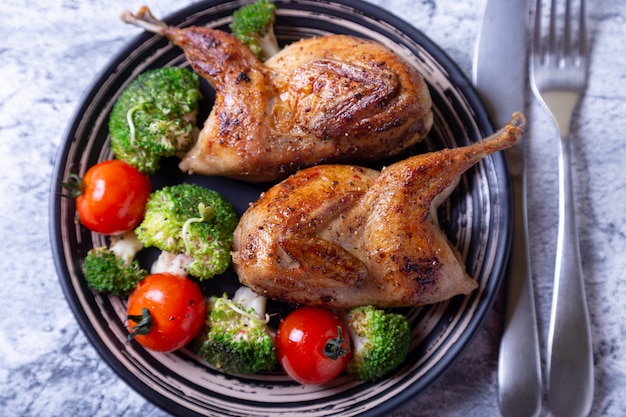 Quaglia fritta intera con broccoli e pomodorini.