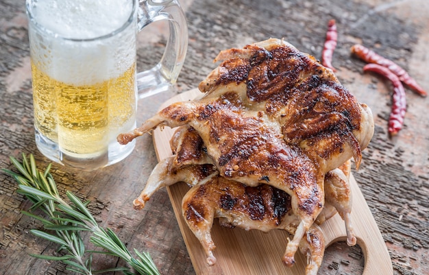 Quaglie alla griglia con un bicchiere di birra