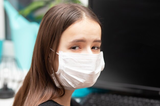 Quarantena al lavoro Giovane donna con maschera antibatterica al lavoro in ufficio