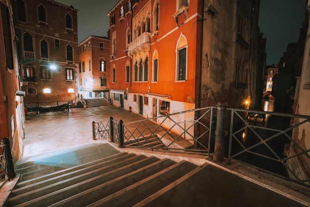 Quartiere gotico con vecchie case in mattoni rossi di notte Vicoli vuoti e scale del ponte a Venezia Italia