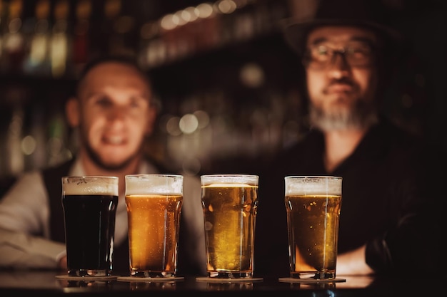 Quattro bicchieri con birre diverse sul bancone del bar nel pub