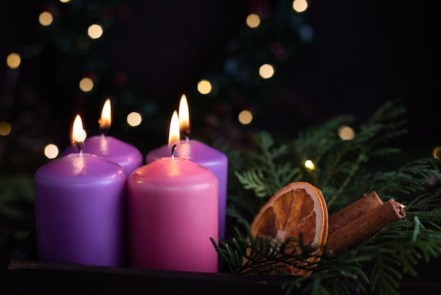 Quattro candele viola dell'avvento alla vigilia di Natale.