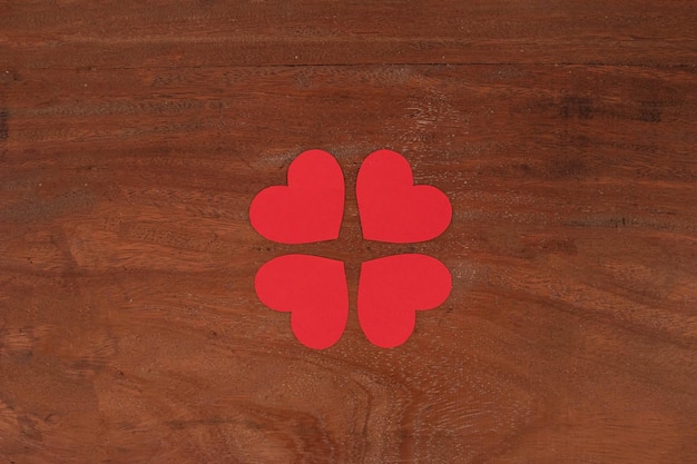 Quattro cuori isolati in uno sfondo di legno
