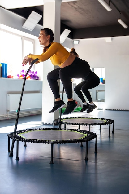 Quattro giovani donne sul trampolino, giovani ragazze fitness si allenano in palestra