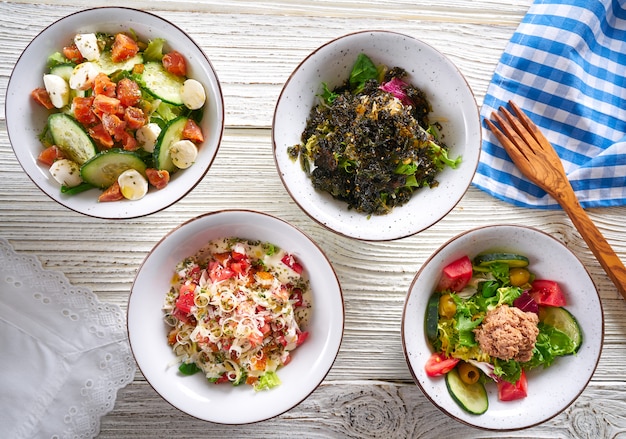 quattro insalatiere mescolano cibo sano