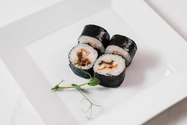 Quattro involtini di sushi maki con salmone decorati con verde