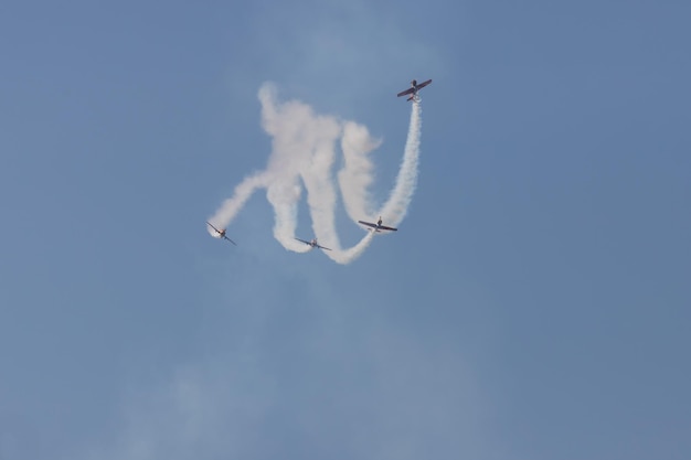 Quattro jet dell'esercito che volano nel cielo blu e si esibiscono in uno spettacolo lasciando segni di fumo