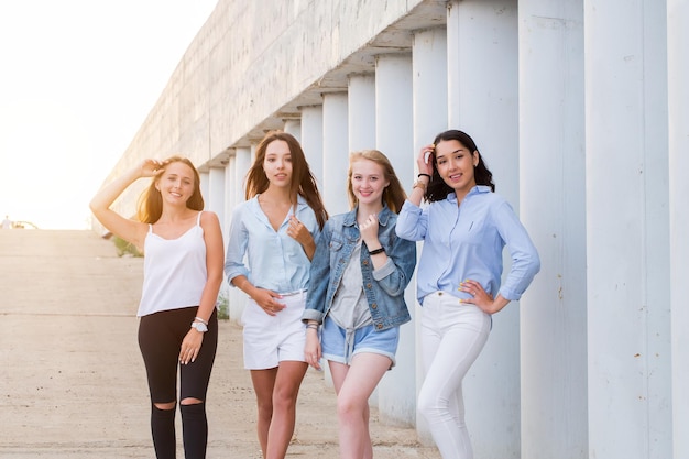 Quattro migliori amiche che guardano insieme la macchina fotografica persone, stile di vita, amicizia, concetto di vocazione