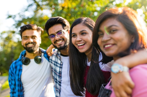 Quattro persone che si divertono all'aperto si concentrano sulla bella donna indiana