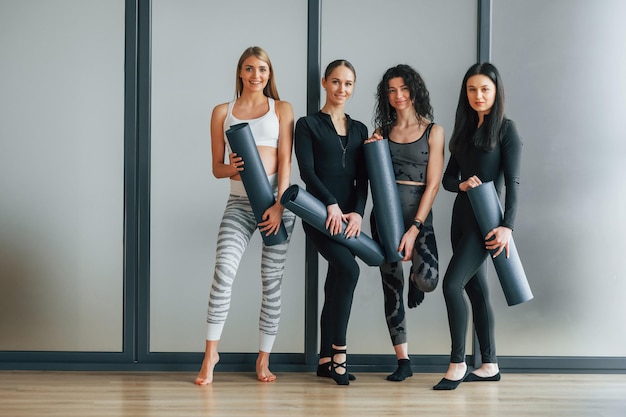 Quattro persone Donne in abiti sportivi in piedi nel centro fitness