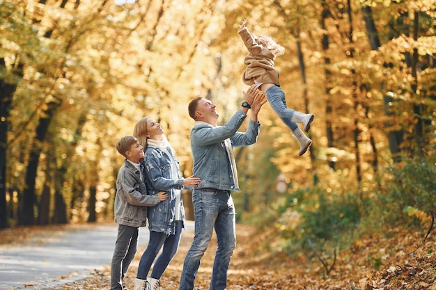 Quattro persone La famiglia felice è insieme nel parco in autunno