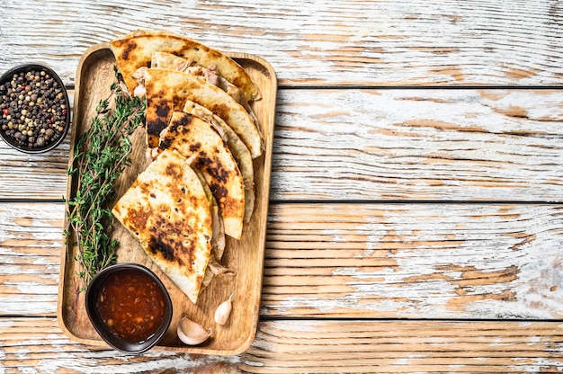 Quesadilla di snack vegetariani con verdure e formaggio su vassoio in legno. Fondo di legno bianco. Vista dall'alto. Copia spazio.